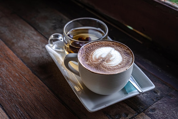 Caffè latte caldo con latte art schiuma di latte in tazza tazza tè caldo sulla scrivania di legno vista dall'alto Come colazione In un caffè Negozio in stile vintage al bar durante il concetto di lavoro aziendale