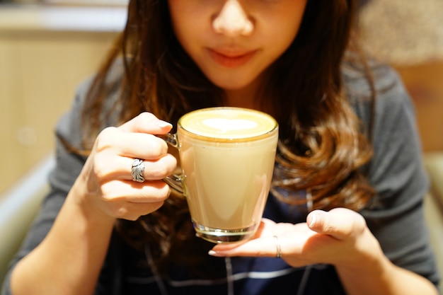 Caffè Latte caldo in mano ragazza asiatica, posta e pronto da bere.