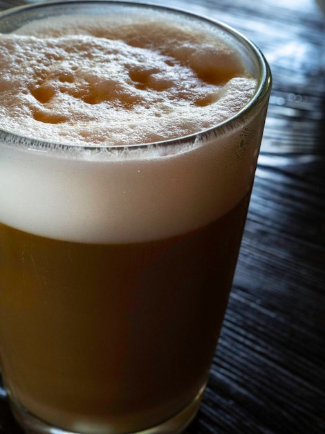 Caffè latte sul tavolo di legno nero vicino alla finestra Pausa caffè