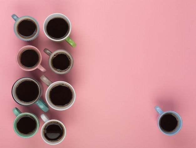 Caffè nelle diverse tazze su sfondo rosa. Flatlay, concetto di giornata allegra