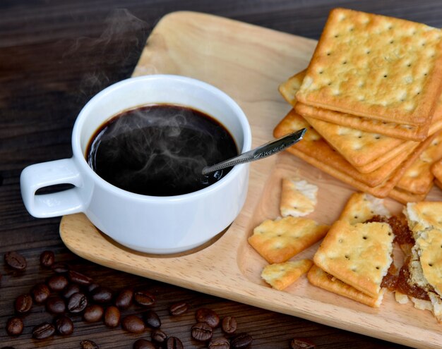 Caffè nero caldo sulla tazza con nucleo di Crackers