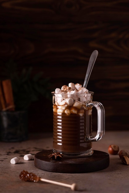 Caffè nero con cannella, anice e marshmallow in una tazza di vetro