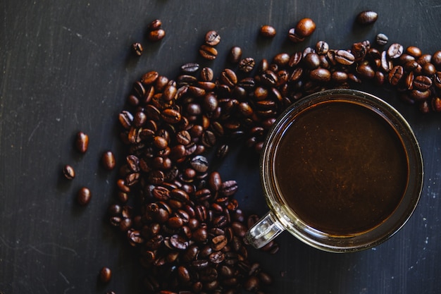 Caffè nero con chicchi di caffè tostato.