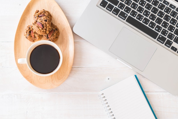 caffè nero e biscotti con laptop e taccuino