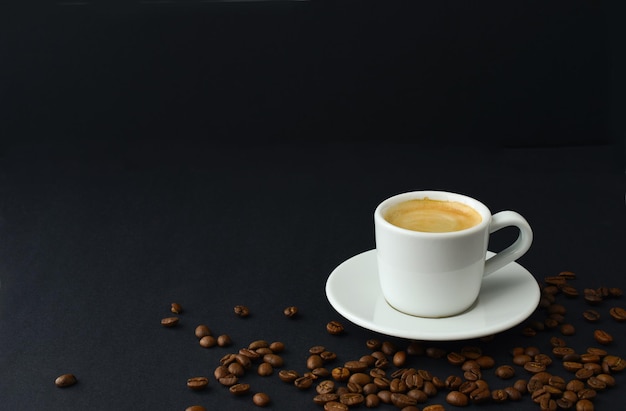 Caffè nero e chicchi di caffè sul tavolo su sfondo nero piccola tazza di caffè espresso coppia copia spazio