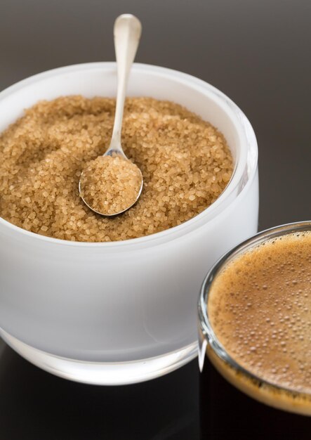 Caffè nero e schiuma in tazza di vetro con zucchero