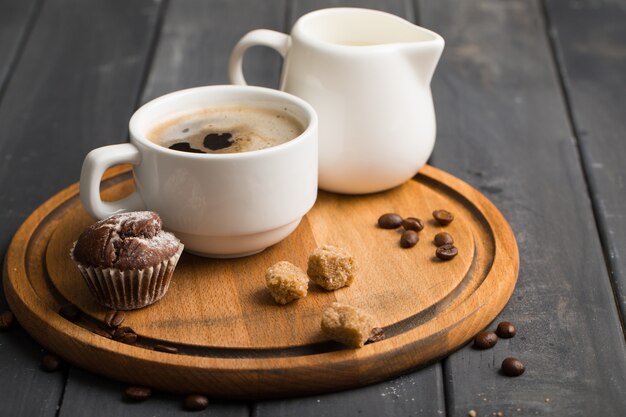 Caffè nero in una tazza su una tavola di legno