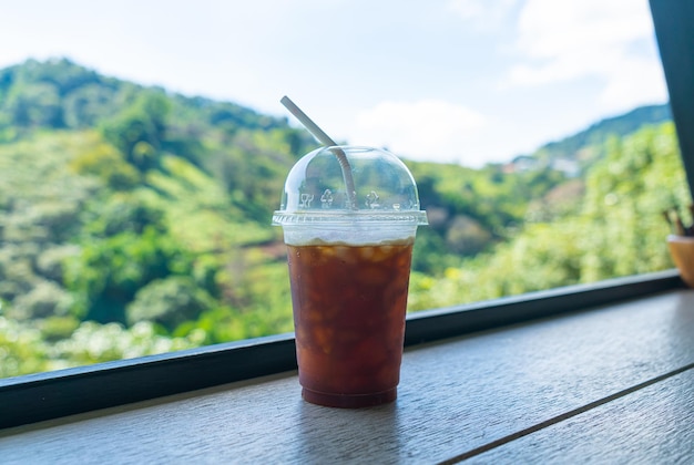 Caffè nero sulla barra di legno con sfondo collina di montagna