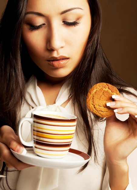 Caffè o tè bevente della donna asiatica