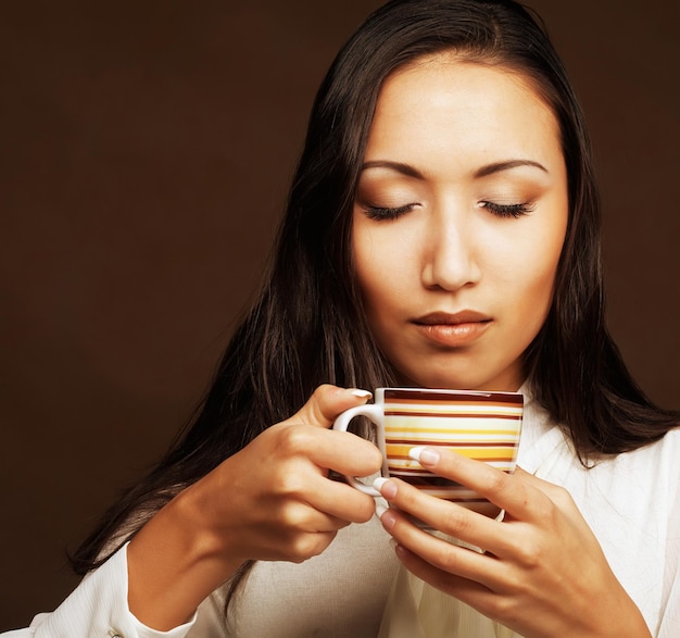 Caffè o tè bevente della donna asiatica