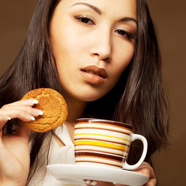 Caffè o tè bevente della donna asiatica