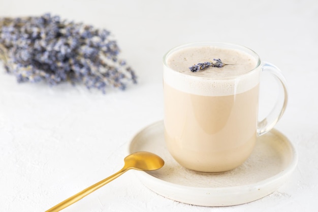 Caffè Raf con latte di cocco e lavanda in una tazza di vetro sul tavolo.