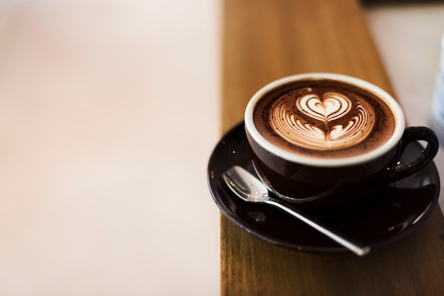 Caffè schiuma schiuma arte sul tavolo di legno