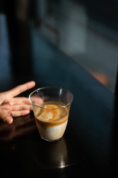 Caffè sporco - Un bicchiere di caffè espresso mescolato con latte fresco freddo nella caffetteria e nel ristorante