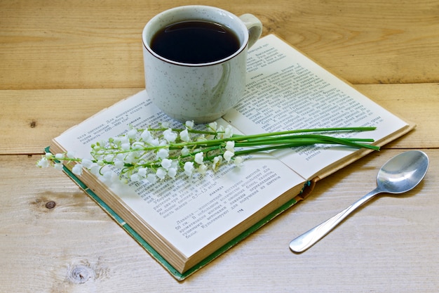 Caffè su uno sfondo in legno e fiori.