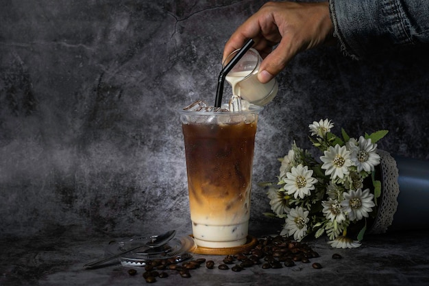 Caffè tailandese in una tazza di plastica alta C'è vapore accanto al vetro freddo