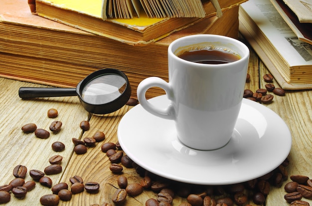 Caffè vecchi libri e lente d'ingrandimento