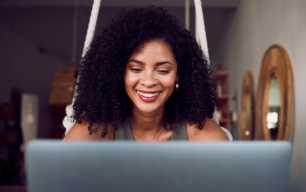 Caffetteria funzionante e volto di donna nera con laptop sorridente felice ed entusiasta di iniziare il progetto Imprenditore libero professionista e donna d'affari che digita, scrive e legge lavoro sul computer nella caffetteria