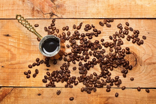 Caffettiera turca e chicchi di caffè su un tavolo in legno rustico