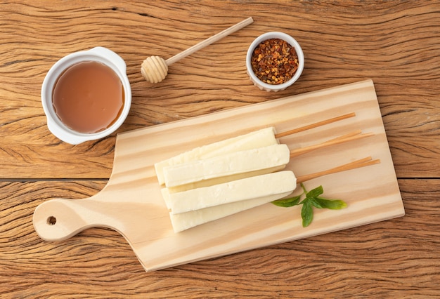 Caglio o formaggio Coalho su una tavola di legno con sciroppo di zucchero e pepe.