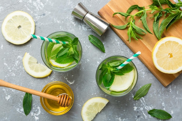 Caipirinha Mojito cocktail vodka o bibita gassata con menta lime e paglia sullo sfondo del tavolo Bevanda rinfrescante con menta e lime in vetro vista dall'alto laici piatta