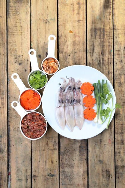 Calamari crudi, carote e carne di maiale, preparare per la cottura.