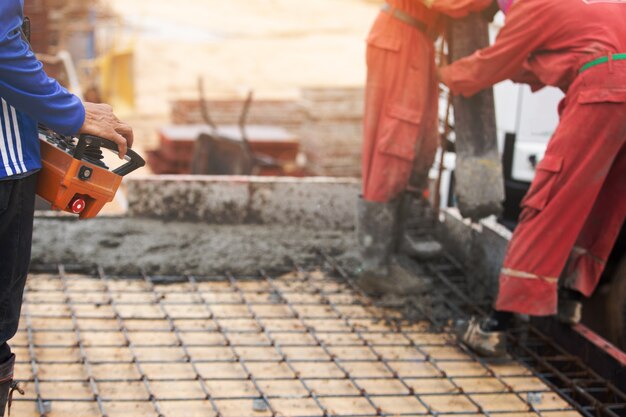 Calcestruzzo dell&#39;asta di controllo del lavoratore degli uomini della costruzione