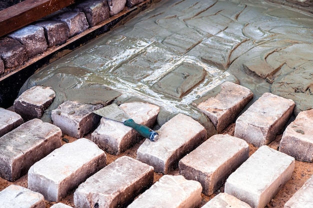 Calcestruzzo delle fondamenta della cazzuola del pavimento del terrazzo del giardino sui mattoni