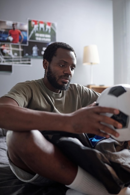 Calciatore contemporaneo che tiene il pallone da calcio