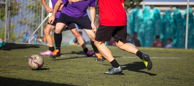 Calciatori di calcio che giocano in un campo di calcio su uno striscione di giornata di sole