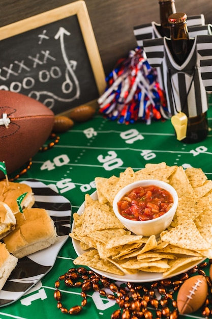 Calcio balilla del giorno della partita con birra, patatine e salsa.