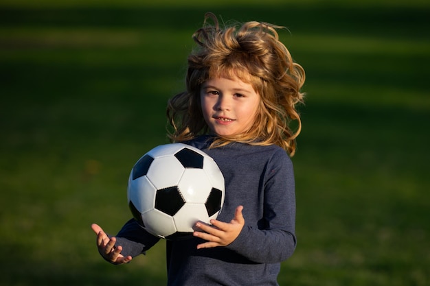 Calcio bambino giocare a calcio Ragazzo che tiene il pallone da calcio vicino al ritratto sportivo dei bambini