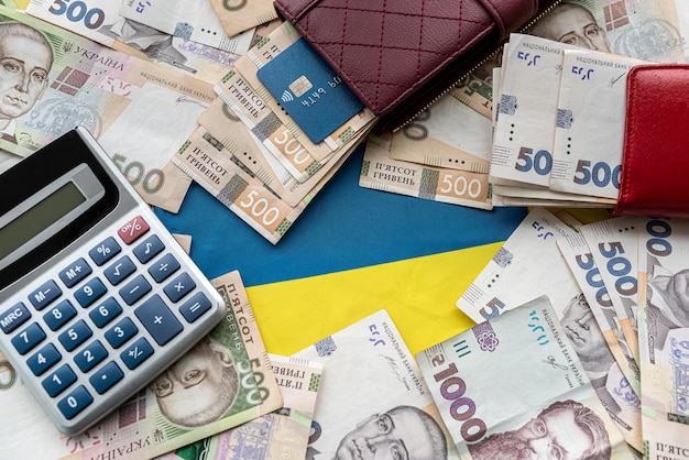 Calcolatrice con carta di credito sul denaro ucraino in borsa come background finanziario