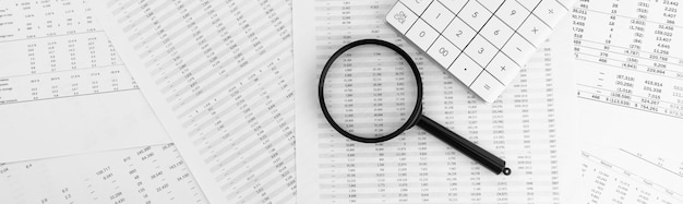 Calcolatrice e lente d'ingrandimento sui documenti finanziari Concetto finanziario e commerciale