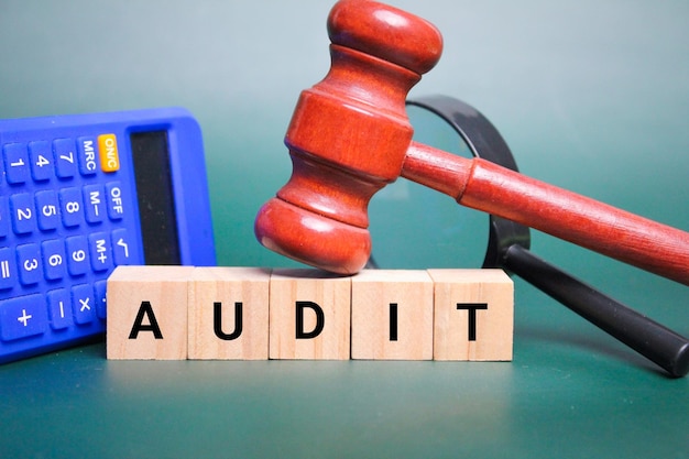 calcolatrice e martelletto con la parola audit. concetto di audit o ispezione