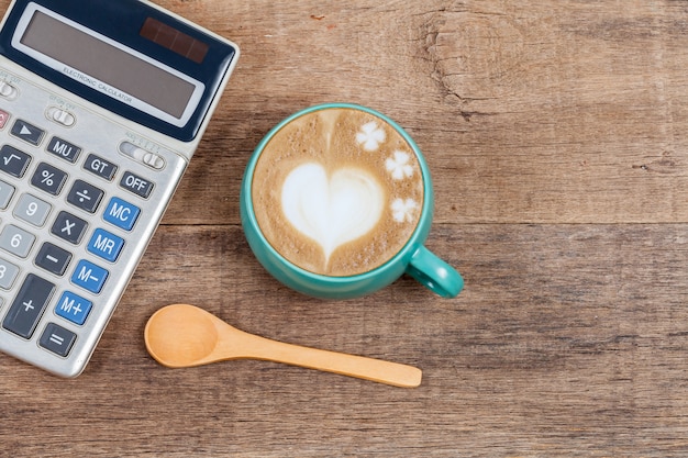 Calcolatrice e tazza di caffè su legno