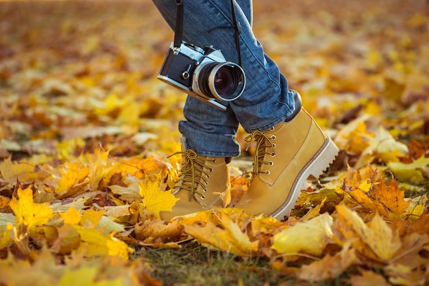 Caldi stivali gialli Camminando tra le foglie d'autunno