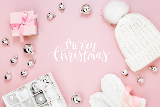 Caldi vestiti invernali e decorazioni natalizie. Disposizione in colori rosa pastello.