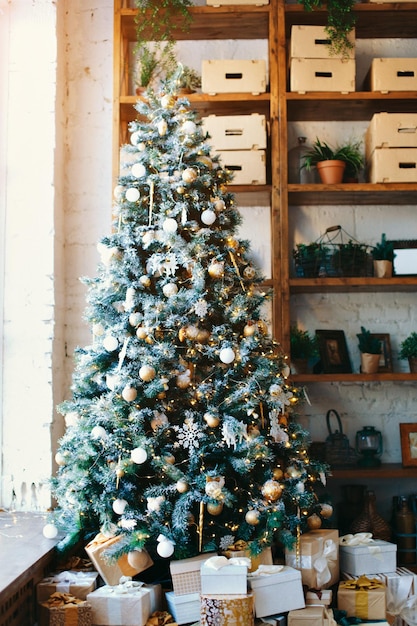 Caldo, accogliente, bel design moderno della stanza in delicati colori chiari decorati con albero di Natale ed elementi decorativi caminetto
