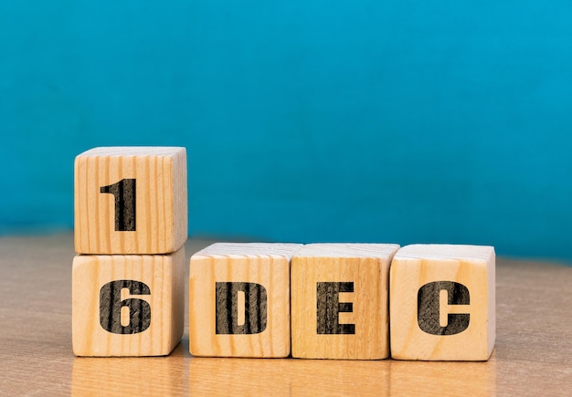 Calendario a forma di cubo per il 16 dicembre su superficie di legno con spazio vuoto per textcube calendario per dicembre su sfondo di legno