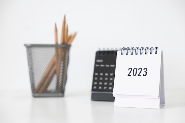 Calendario aziendale 2023 e matita sul tavolo dell'ufficio nel giorno del nuovo anno Fare un piano di lavoro per l'inizio dell'anno Concetto di celebrazione Affari Natale Capodanno