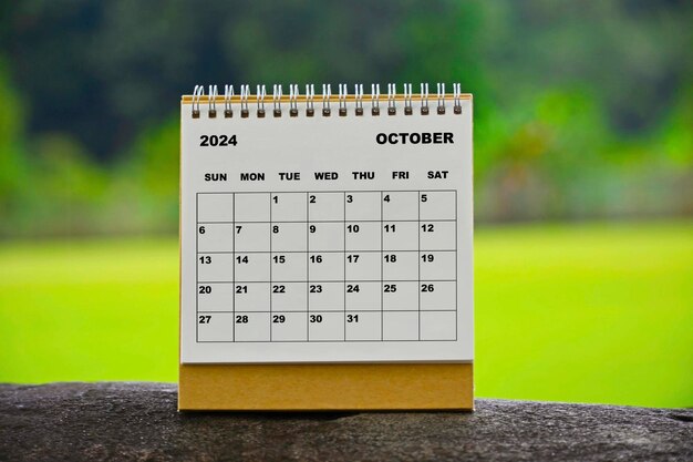 Calendario bianco di ottobre 2024 con sfondo verde sfocato