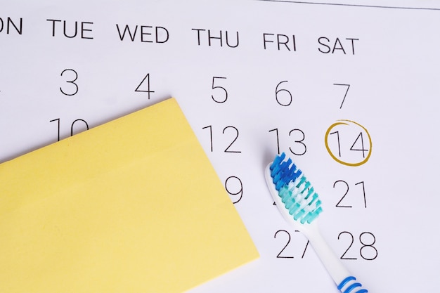 Calendario con una data marcata e uno spazzolino da denti.