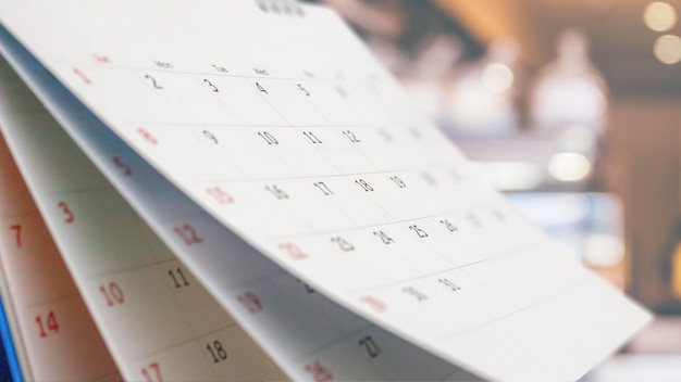 calendario da tavolo cartaceo con sfondo sfocato bokeh appuntamento e concetto di riunione d'affari