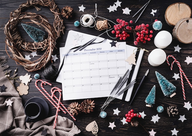 Calendario dicembre 2021 con decorazioni natalizie vista dall'alto piatto giaceva su sfondo di legno scuro