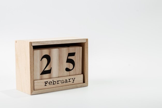 Calendario in legno 25 febbraio su sfondo bianco