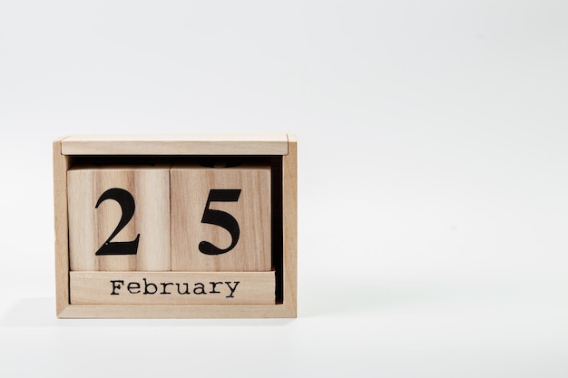 Calendario in legno 25 febbraio su sfondo bianco
