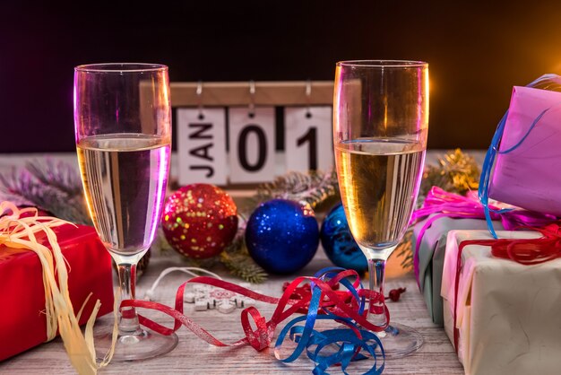 Calendario in legno con bicchieri di champagne e decorazioni di capodanno su tavola di legno