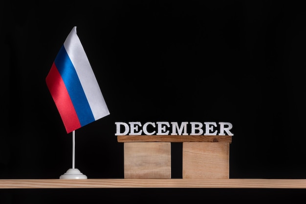 Calendario in legno di dicembre con bandiera russa su sfondo nero Date in Russia nel mese di dicembre