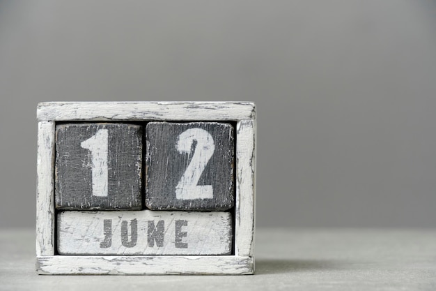 Calendario per il 12 giugno fatto di cubi di legno su sfondo grigioCon uno spazio vuoto per il tuo testo